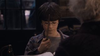 Harry Potter holding a wand for the first time.