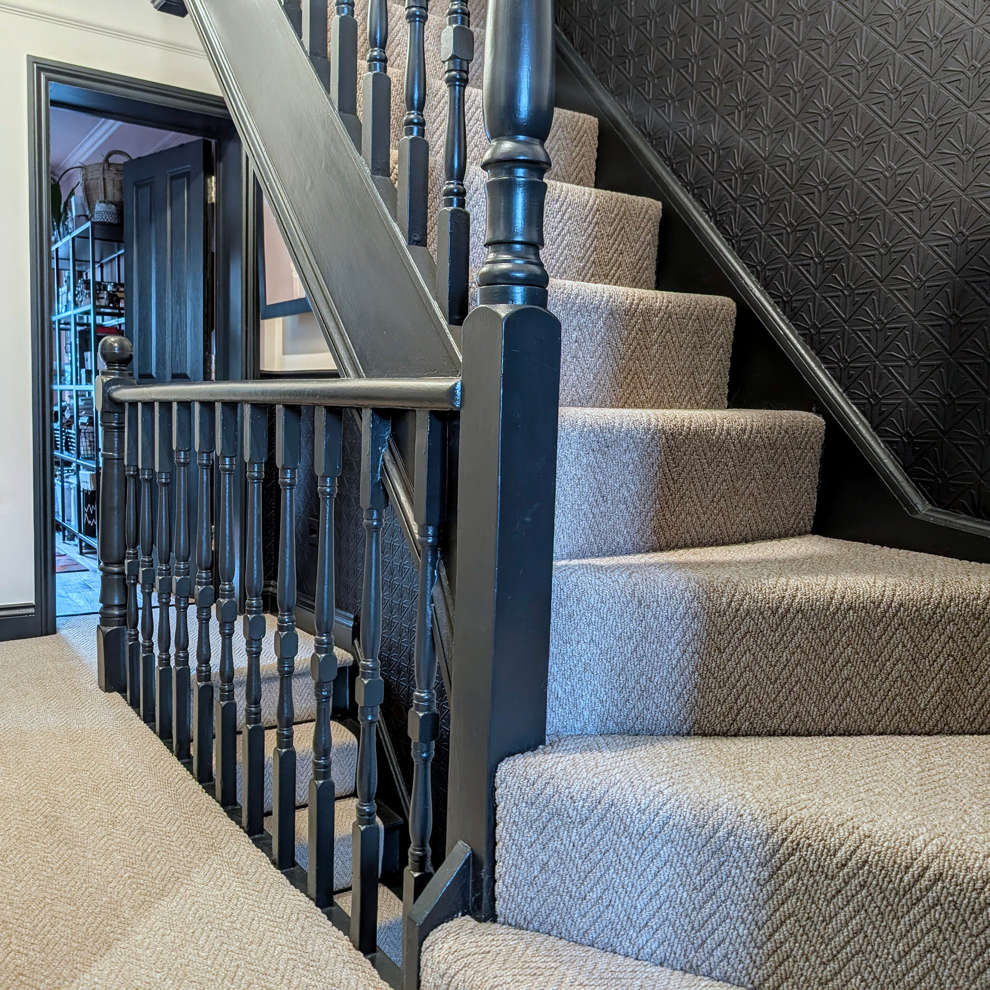 Staircase painted in blue-black with grey carpet runner