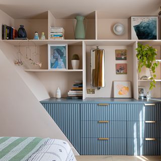 Blue fluted dressers in bedroom alcove, decorated with personal items and home decor