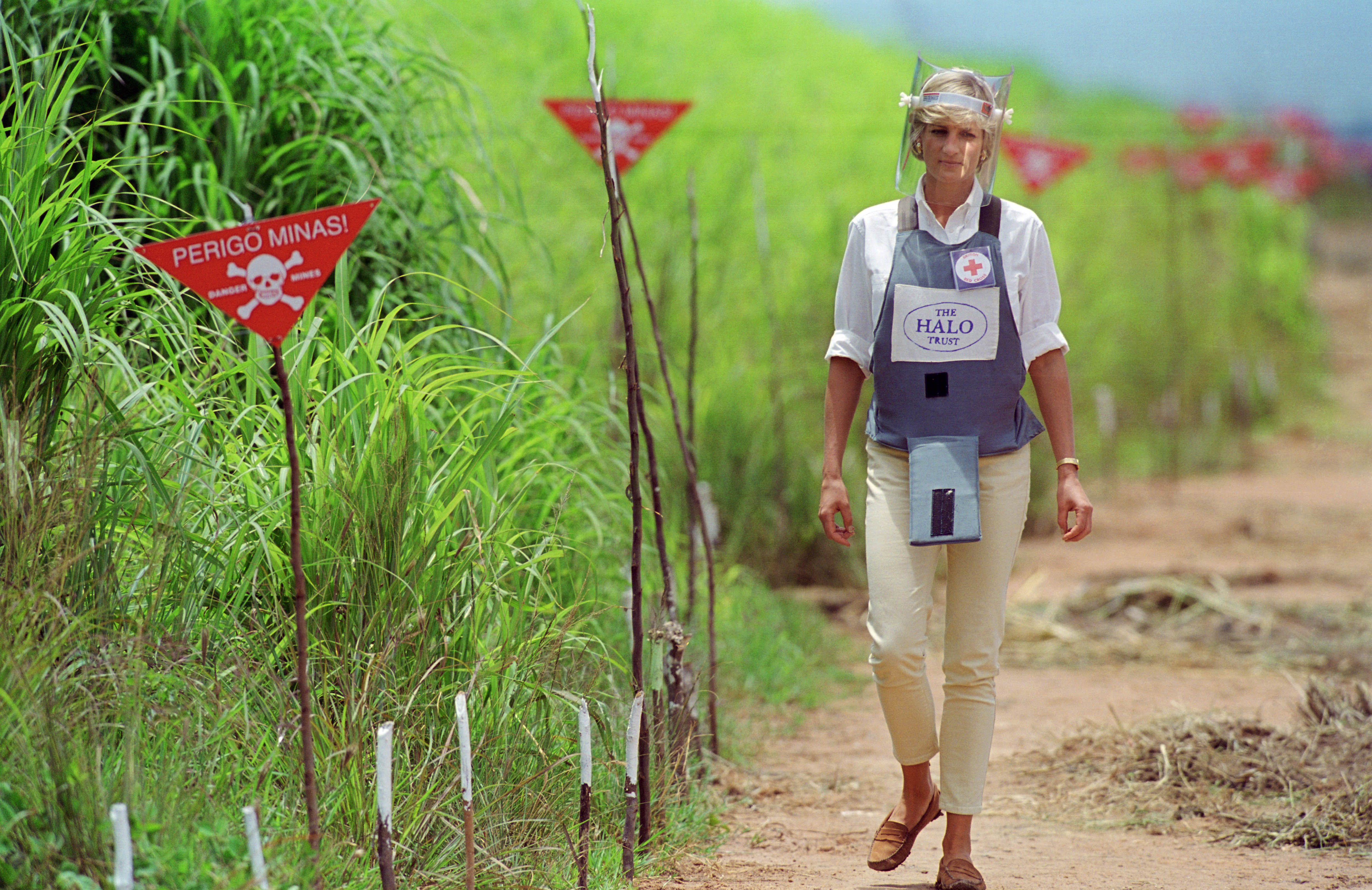 Princess Diana walking through a minefield wearing a vest and face shield
