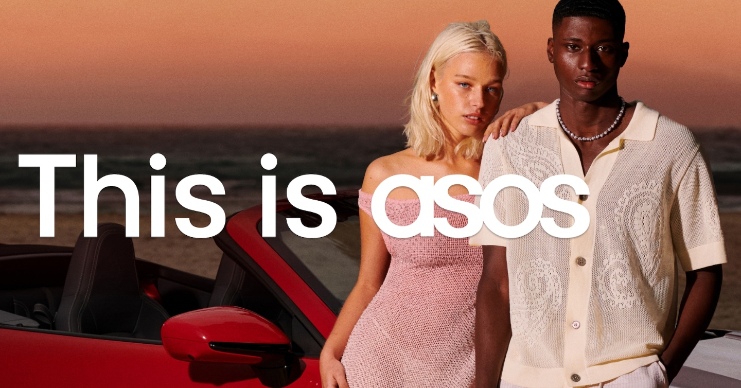 A man and a woman standing in front of a red car with a sunset behind them with the words &#039;this is asos&#039; writting in front of them in white