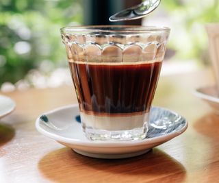 vietnamese coffee in a glass, on a saucer, on a wooden table