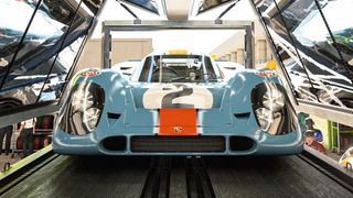 A sky blue sports car with an orange stripe down its center. The number 2 is embossed onto the bonnet in a black and white decal style.