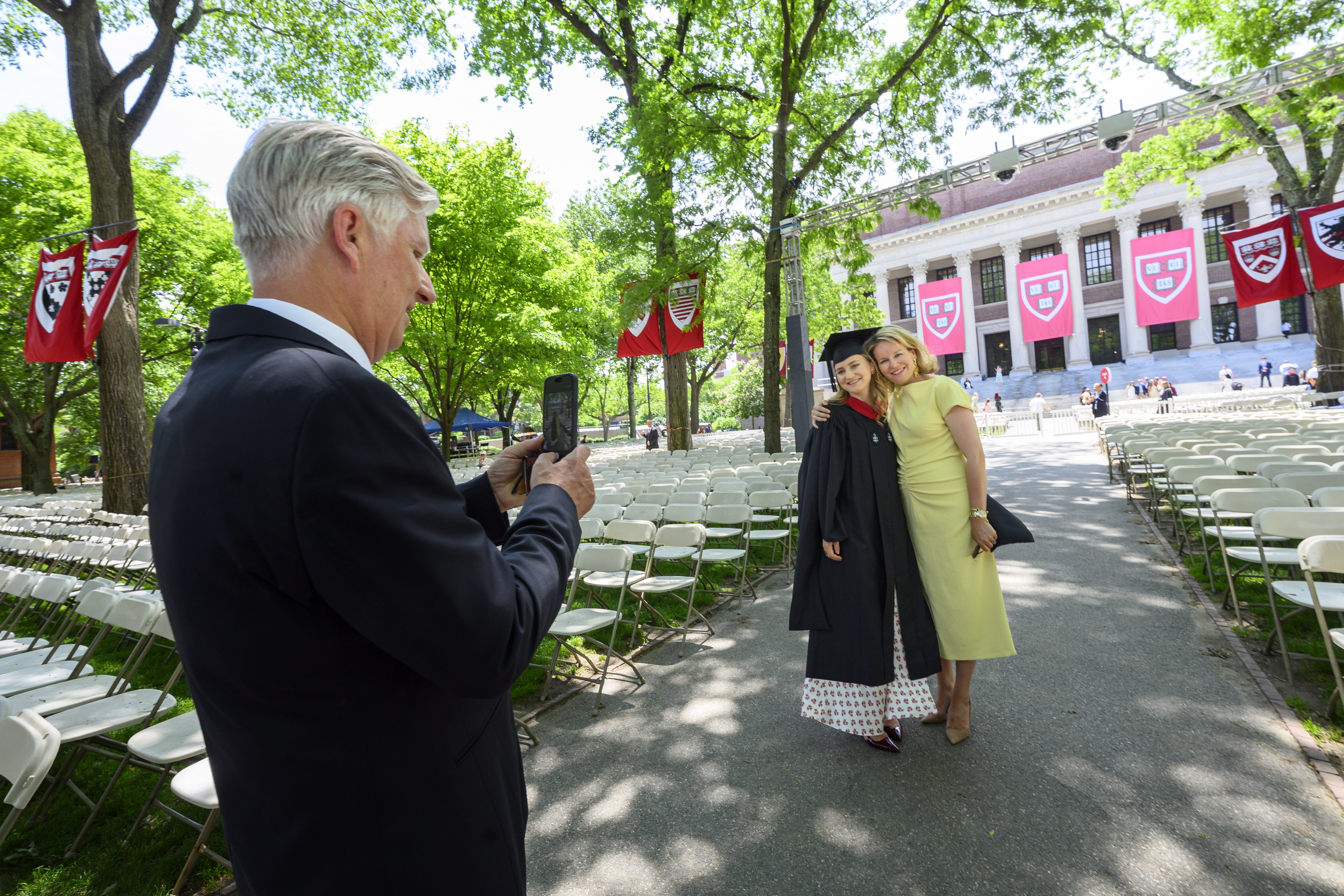 King Philippe taking a picture of Queen Mathilde and Princess Elisabeth at Harvard