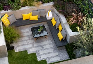 Patio yard space with built in seating and yellow cushions
