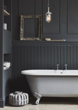 Black bathroom with light grey bath