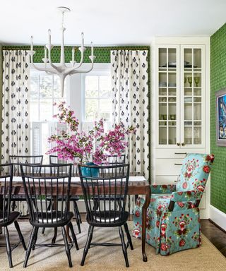 dining room with green walls and patterned chairs and curtains