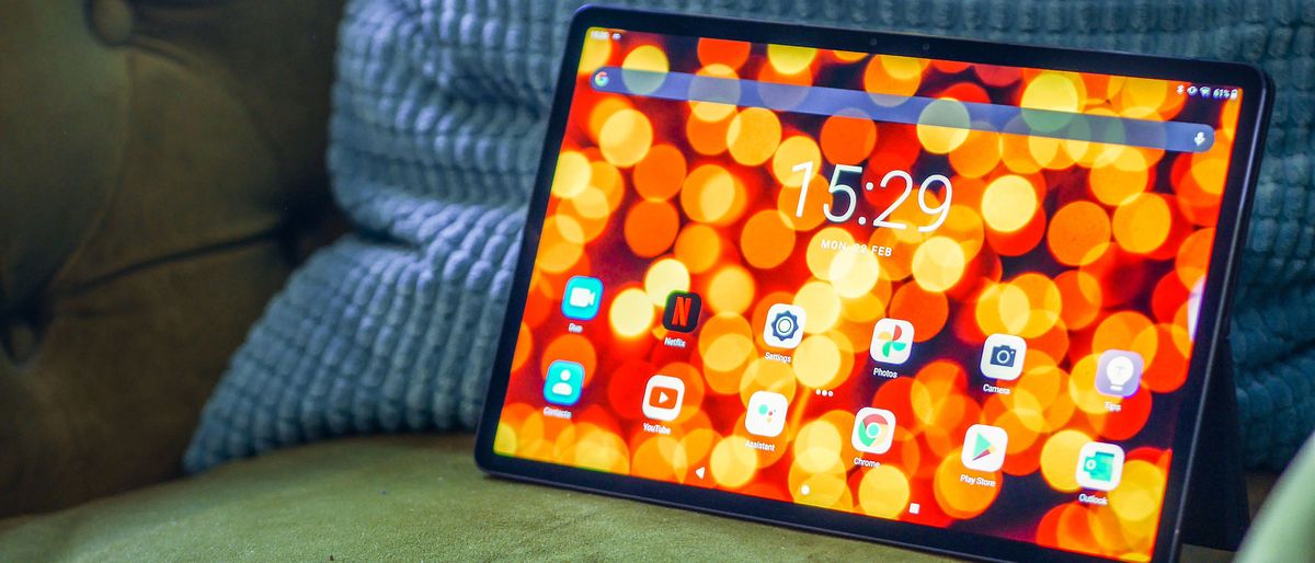 A Lenovo Tab P11 Pro with the screen on, resting against a cushion