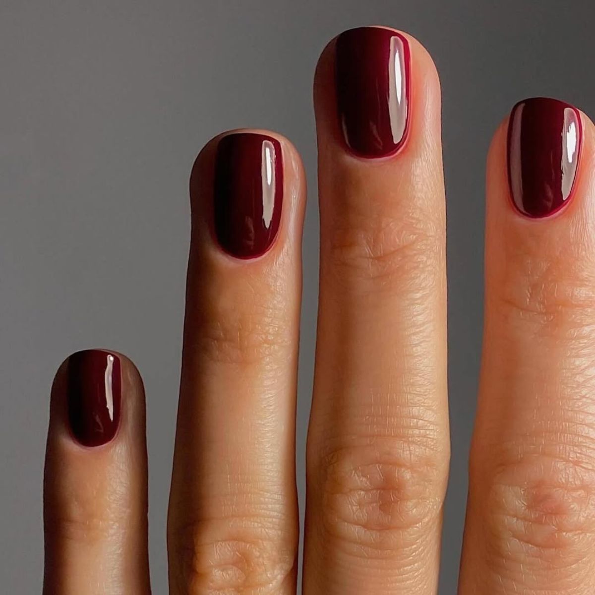 a close up of a woman&#039;s burgundy nails