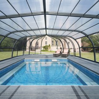 swimming pool with roof and lounge seat