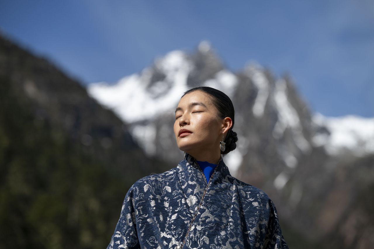 Portrait of a woman in a shawl in front of snowy mountains