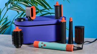 the dyson airwrap ID in teal and terracotta colorway (patina and orange) with a lapis case, with a brush, hairfryer, curling wand attachments