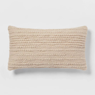 A light beige textured lumbar throw cushion