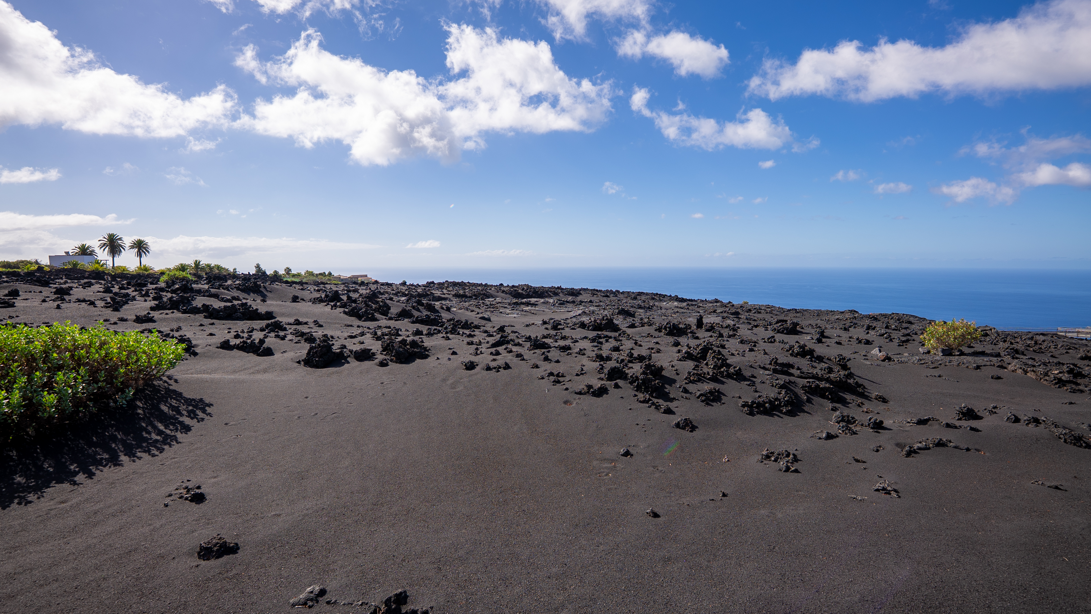 vast black lava field with blue ocean in the distance
