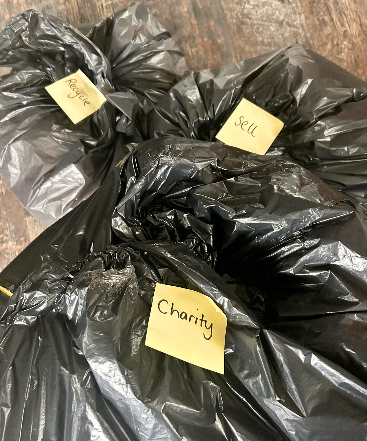 Three black bin bags with yellow Post-it notes