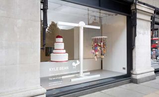 A wedding cake is strung up beside a mobile of its components