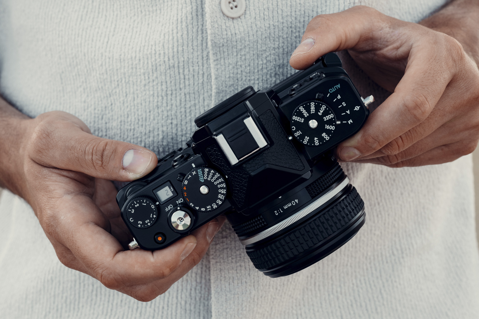 Nikon Z f in photographer's hand, view of the retro top plate