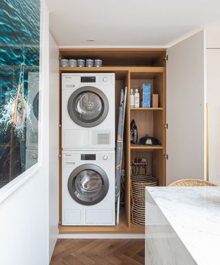 stacked washing machine and tumble dryer in a laundry cupboard