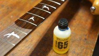 Applying oil to a bass guitar fretboard