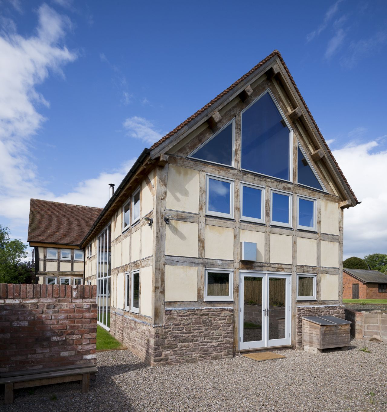 front of barn extension with exposed timber and white render