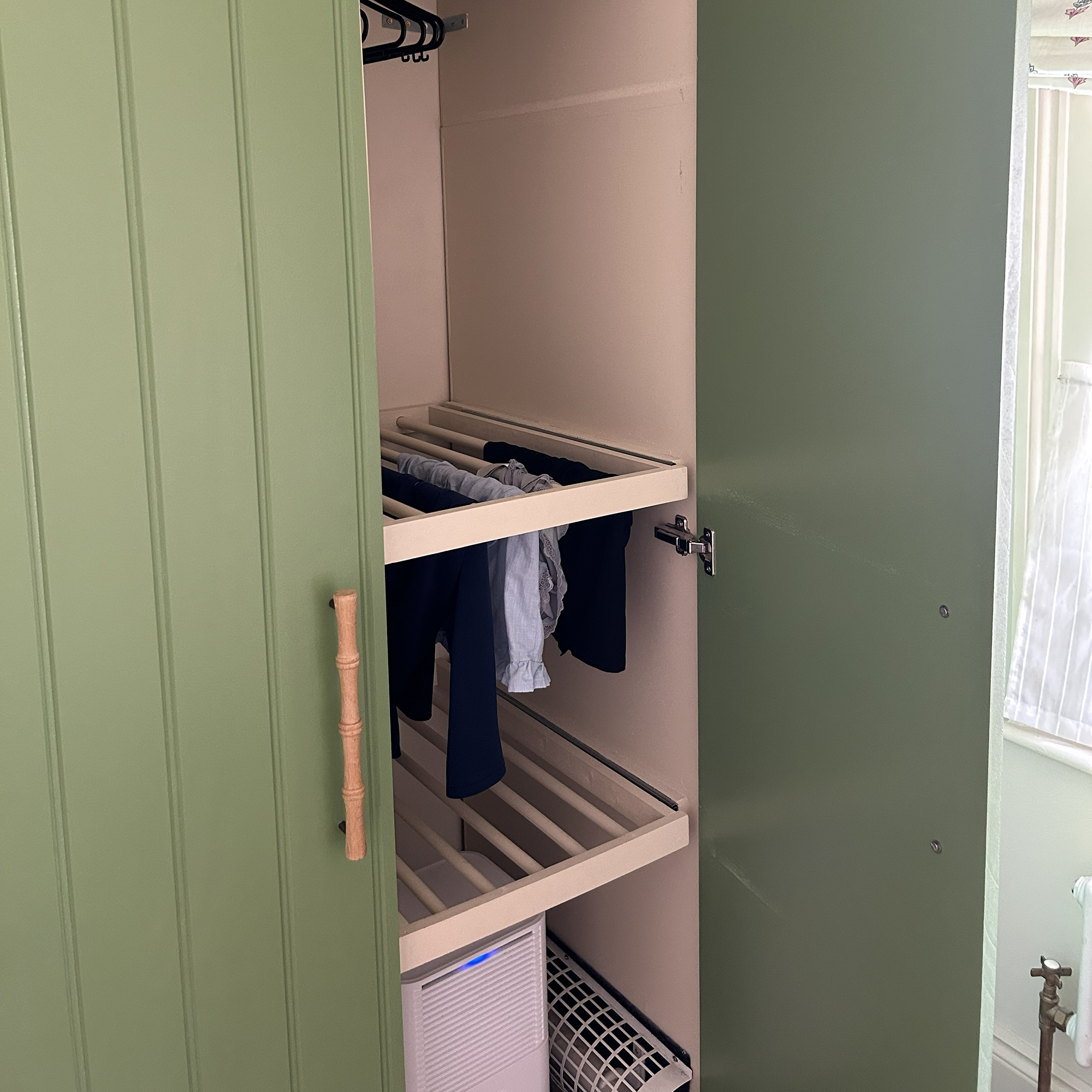 Green laundry room with laundry racks in cupboard
