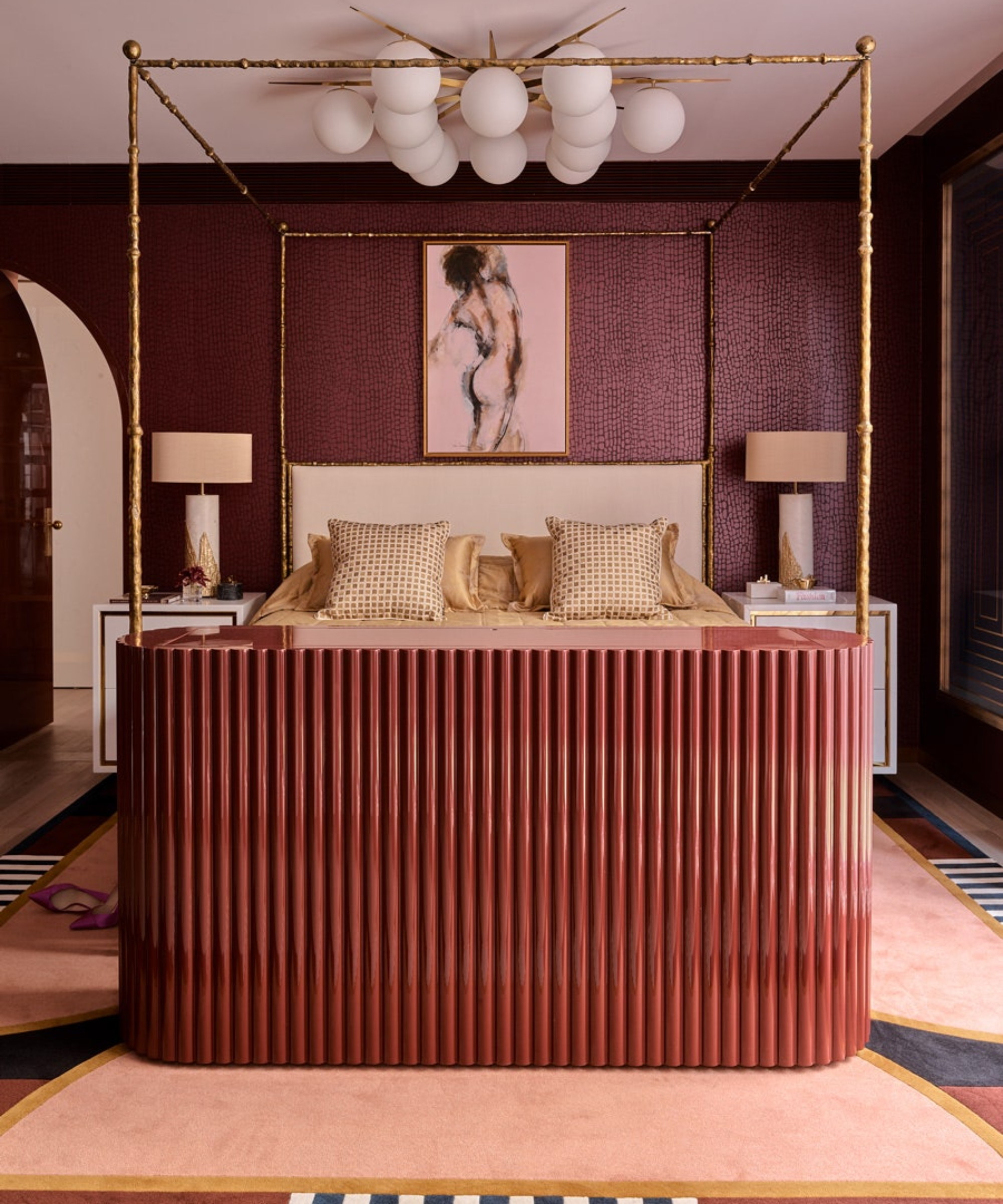 pink bedroom with fluted cabinet at end of bed