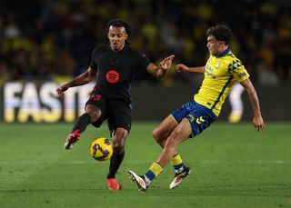 Jules Kounde of FC Barcelona is challenged by Stefan Bajcetic of UD Las Palmas during the LaLiga match between UD Las Palmas and FC Barcelona at Estadio Gran Canaria on February 22, 2025 in Las Palmas, Spain.