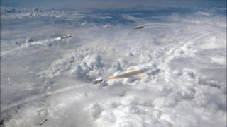 a small missile streaks through the sky above the clouds