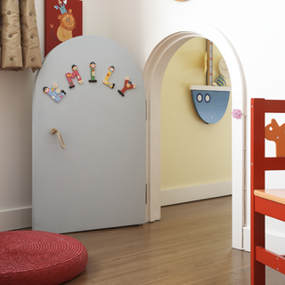kids room with white semi arched door and wooden flooring