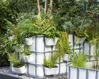 Fall planter ideas with grasses and ferns in white container with shelves at Chelsea Flower Show 2021