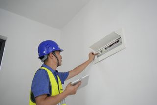 A profesisional electrician checking a consumer unit