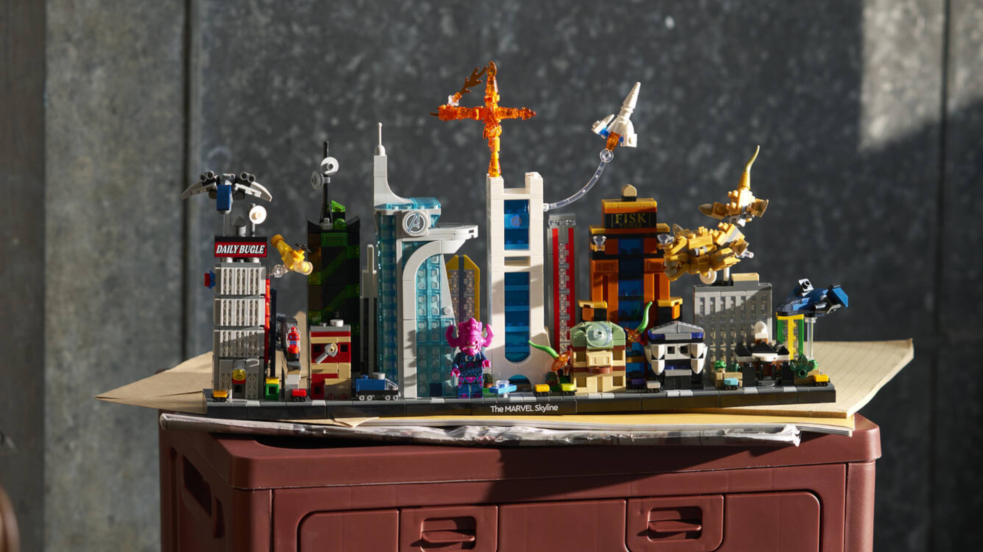 Lego The Marvel Skyline set on a chest in a dark gray room