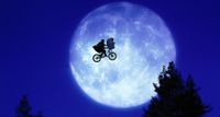 A bicycle flying through the air with a full moon in the background