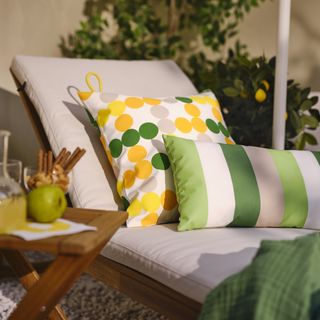 A sun lounger with bright green and yellow pillows
