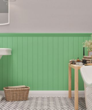A bright green shiplap panel with black and white diamond tiles on the floor, a woven storage basket on the floor, a light wooden table with towels, toiletries and flowers on it, and a white bath tub to the right