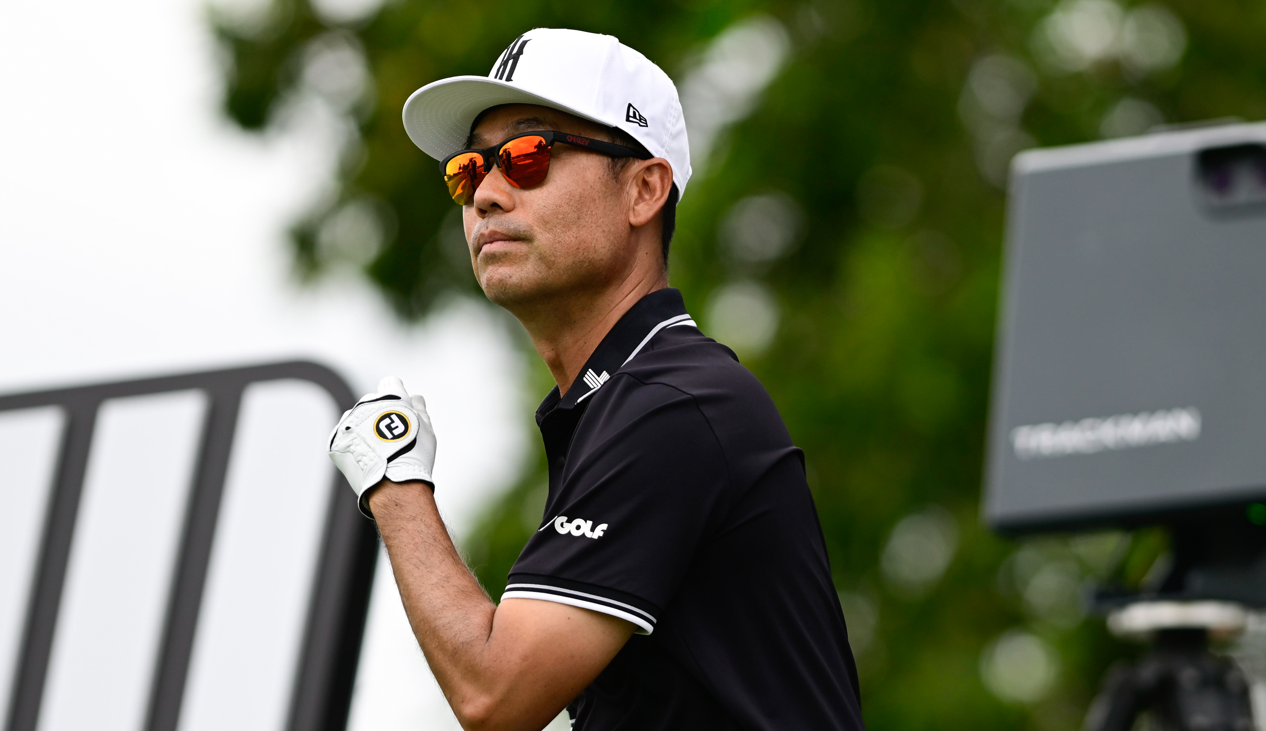 Kevin Na looks on as he hits a tee shot