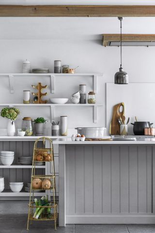 small kitchen island idea with grey pannelling in a grey kitchen with cooking utensils and accessories