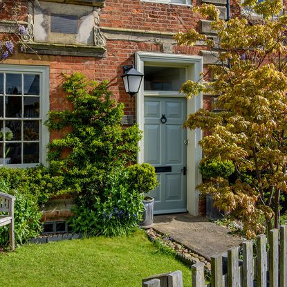 house exterior with brick wall and garden area