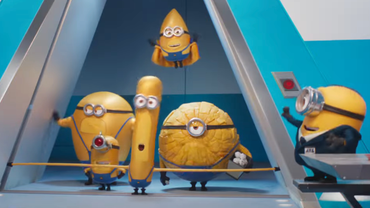 The Mega Minions exit an elevator into their office in front of another black suit Minion in Despicable Me 4.