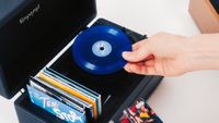 A hand putting a 4-inch Tiny Vinyl record onto the Tiny Vinyl Player record deck.