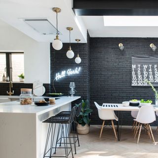 kitchen with black painted monochromatic brick wall and white countertop