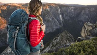 Woman wearing hiking backpack looking out across mountain range