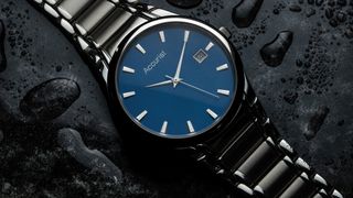 A close-up of an Accurist watch with a sleek blue dial, silver hour markers, and a stainless steel bracelet on a wet surface