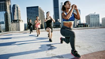 Woman performing lunges on a rooftop