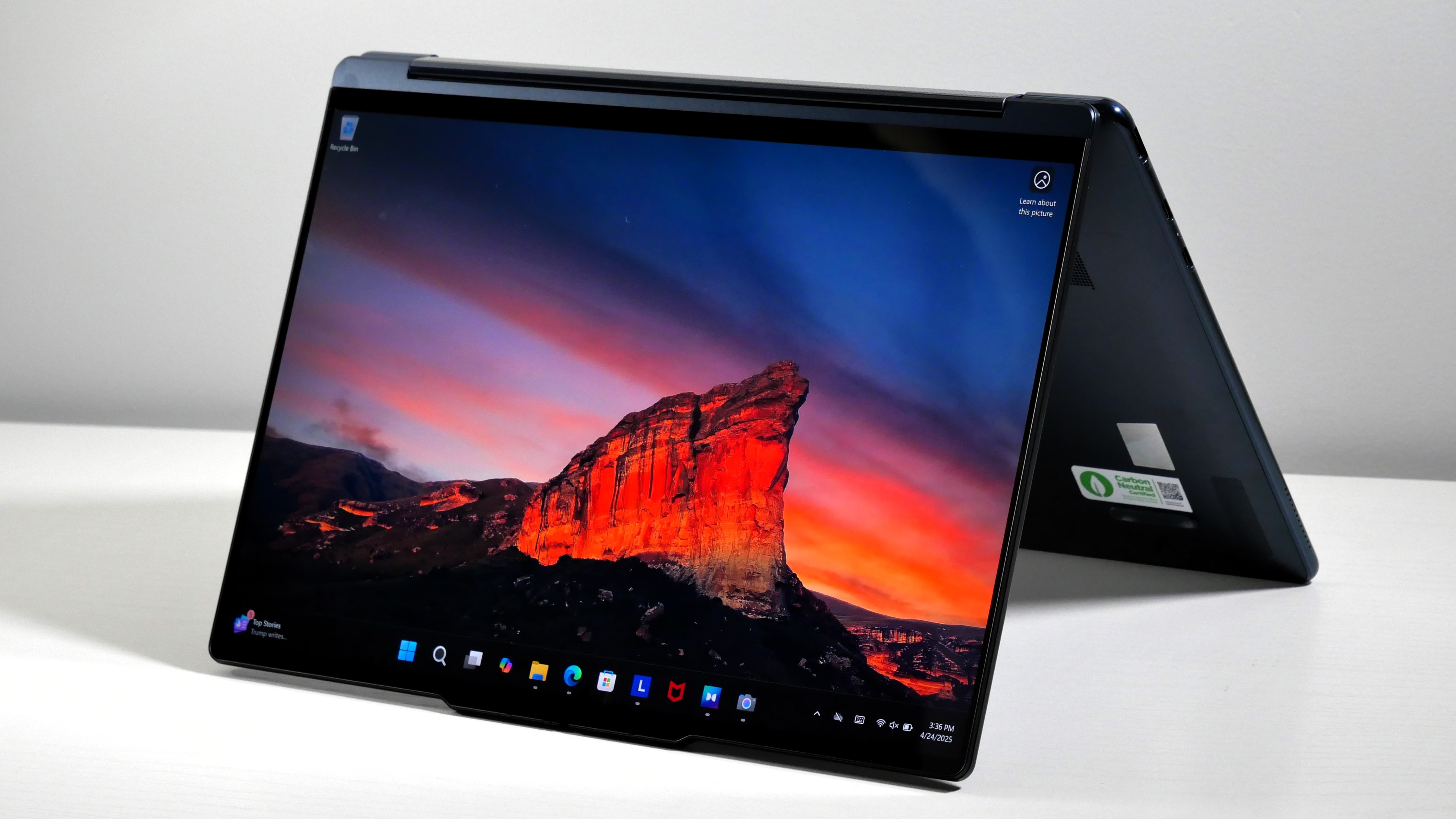 Lenovo Yoga 9i 2-in-1 Aura Edition open on a white desk in tent mode.