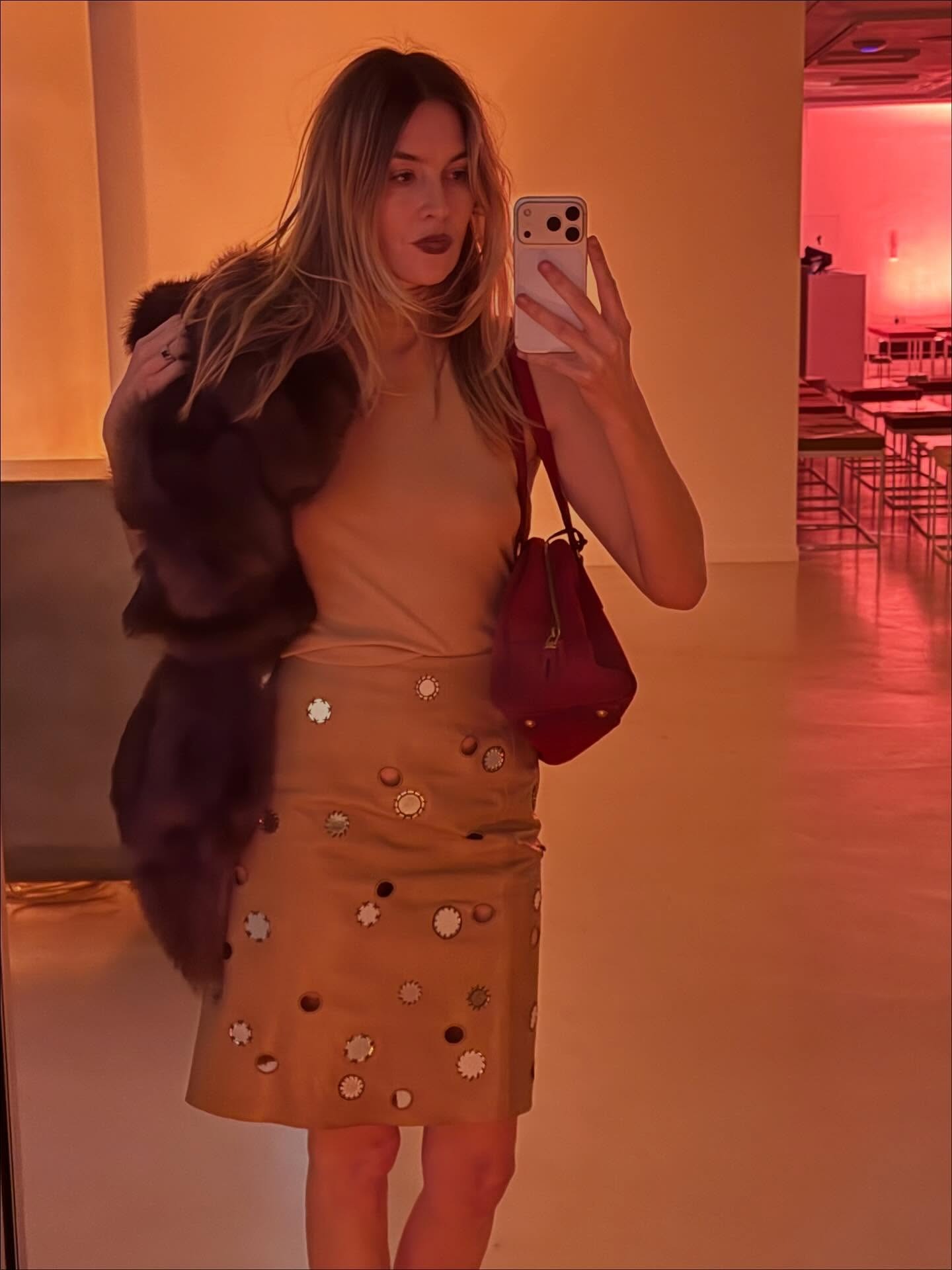 French influencer @camillecharriere wears a mirrored Prada knee-length pencil skirt with a sleeveless beige knit.