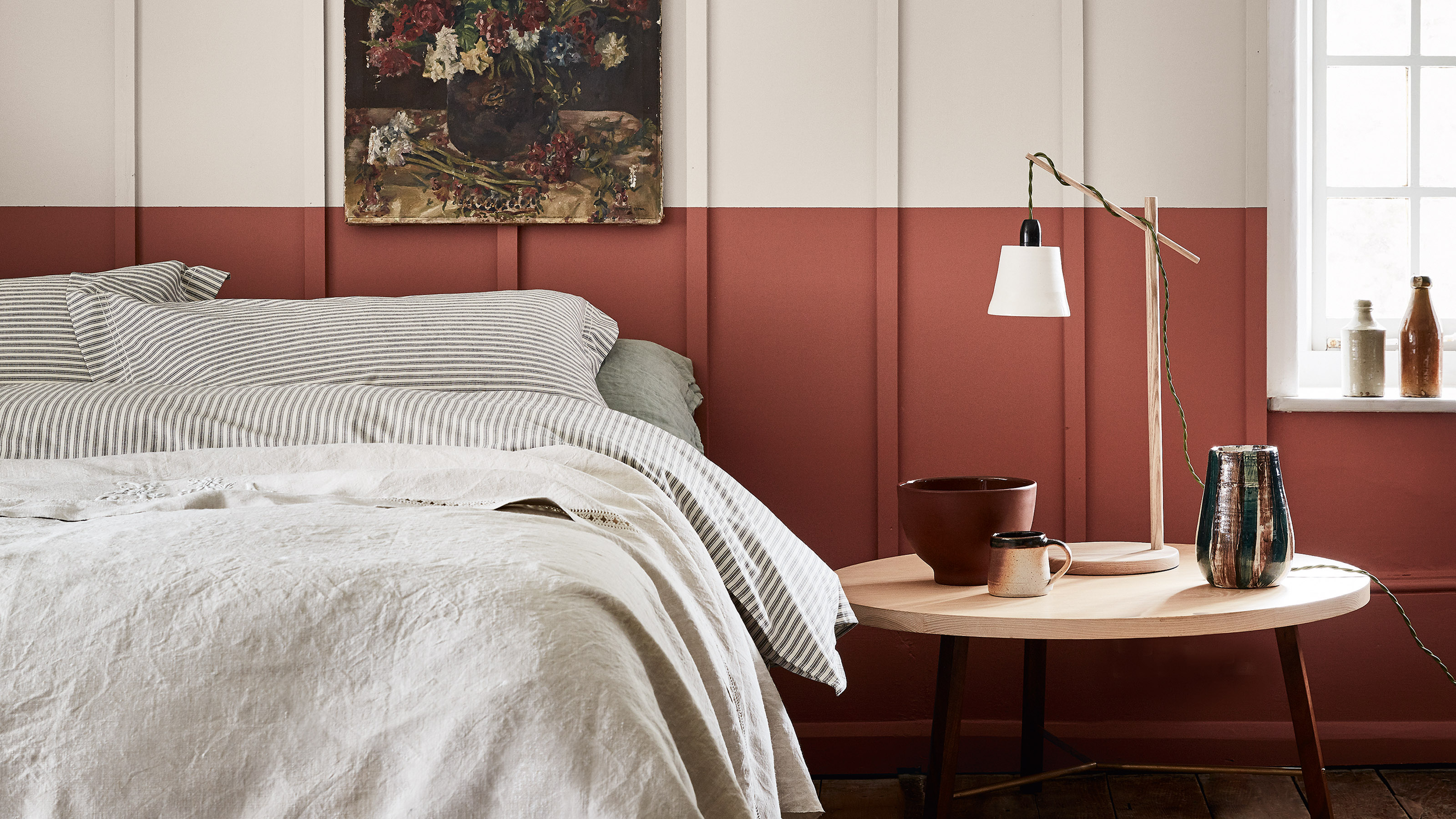 A bedroom painted in off-white and deep terracotta Little Greene paint