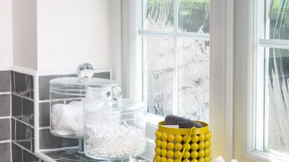 A bathroom window with toiletries displayed on the window sill