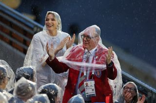 Princess Charlene and Prince Albert II of Monaco look upbeat during the rain while attending the Olympic Games Opening Ceremony in Paris on July 26, 2024.