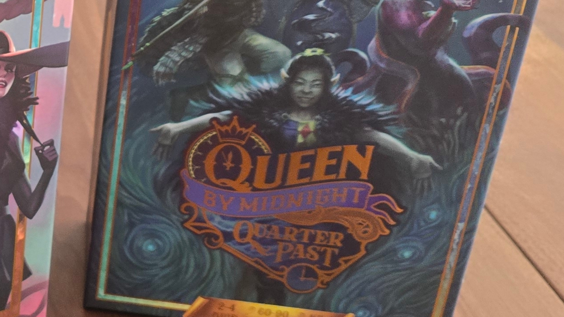 Queen by Midnight Quarter Past expansion box on a wooden table